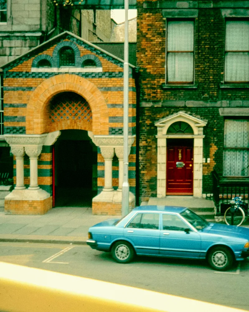 The same street scene after a cross-processed 80s treatment with cyan shadows and warm highlights.